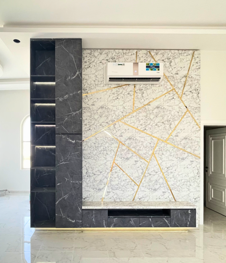 Marble-look media wall with gold inlay lines and black side column by Al Malek Carpentry, Ras Al Khaimah