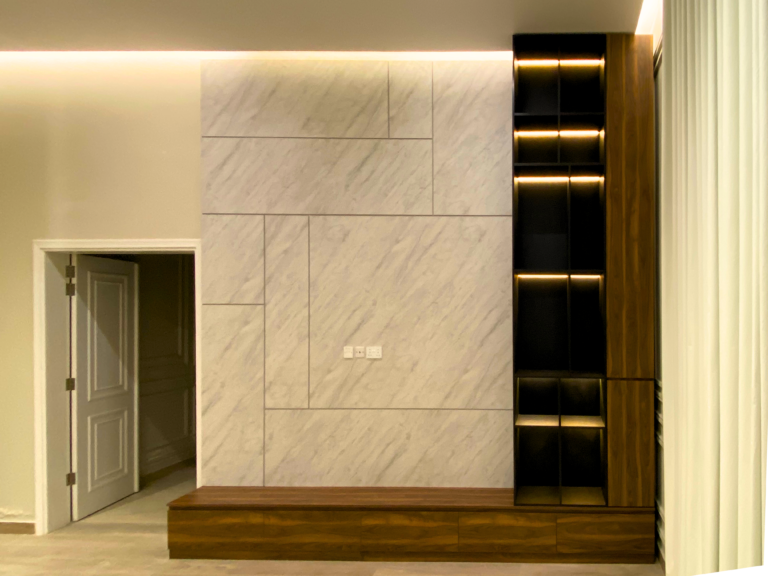 جدار بمظهر رخامي مع وحدة رفوف سوداء مضاءة، من تنفيذ منجرة الملك في رأس الخيمة