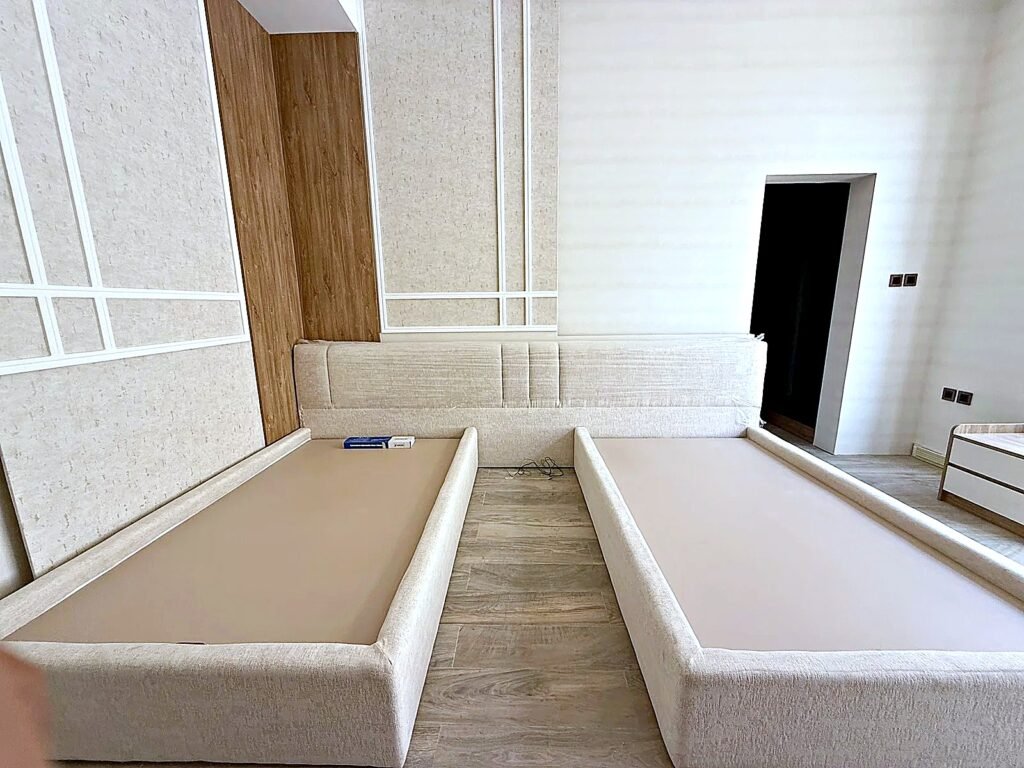 Upholstered twin bed frames showing the full 18 mm plywood base used in every Al Malek bed