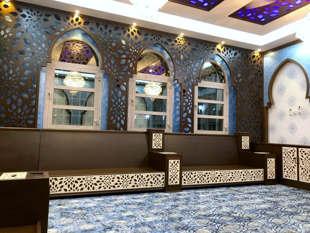 Majlis wall with CNC-cut floral lattice panels framing arched windows, with matching CNC ceiling panels, by Al Malek Carpentry