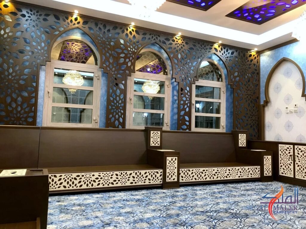جدار مجلس بألواح شبكية زهرية مقصوصة بالـCNC تحيط بنوافذ مقوّسة، مع ألواح سقف مطابقة، من تنفيذ منجرة الملك