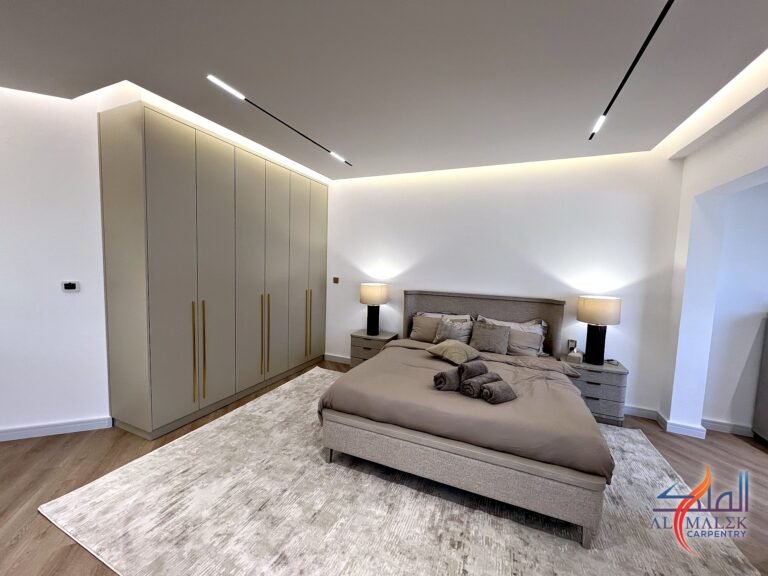 Penthouse master bedroom in Bab Al Bahar, Ras Al Khaimah, with a full-height built-in wardrobe, upholstered bed and LED cove ceiling by Al Malek Carpentry