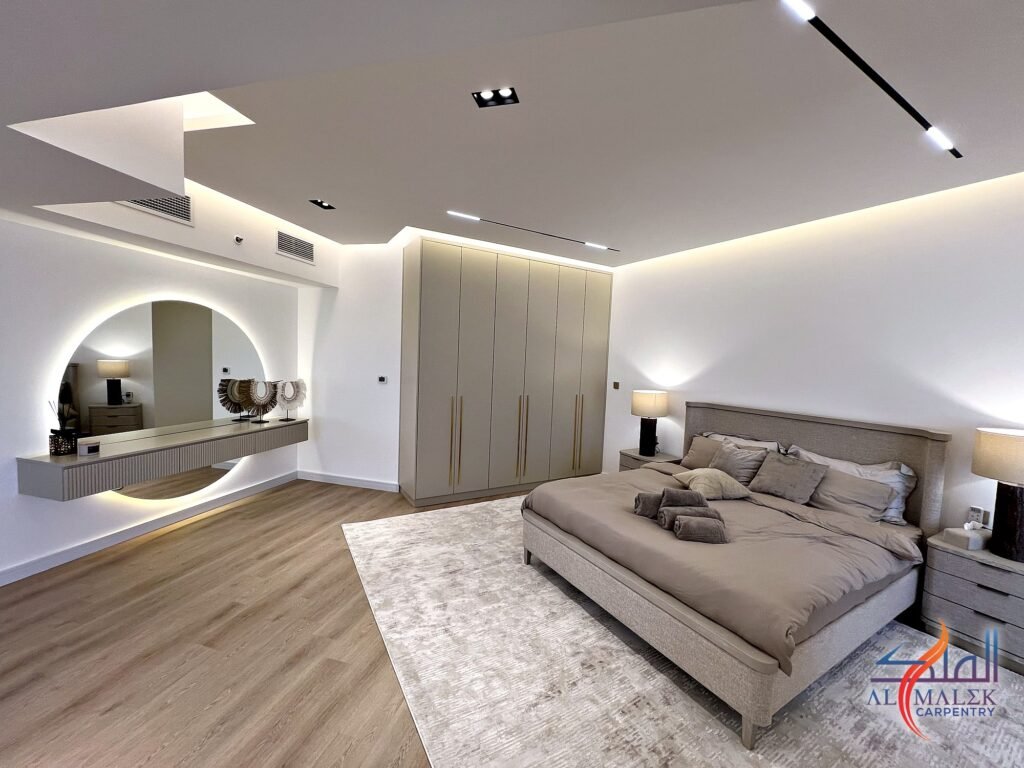 Wide view of a penthouse master bedroom in Bab Al Bahar with dressing table, built-in wardrobe, bed and ceiling design by Al Malek Carpentry